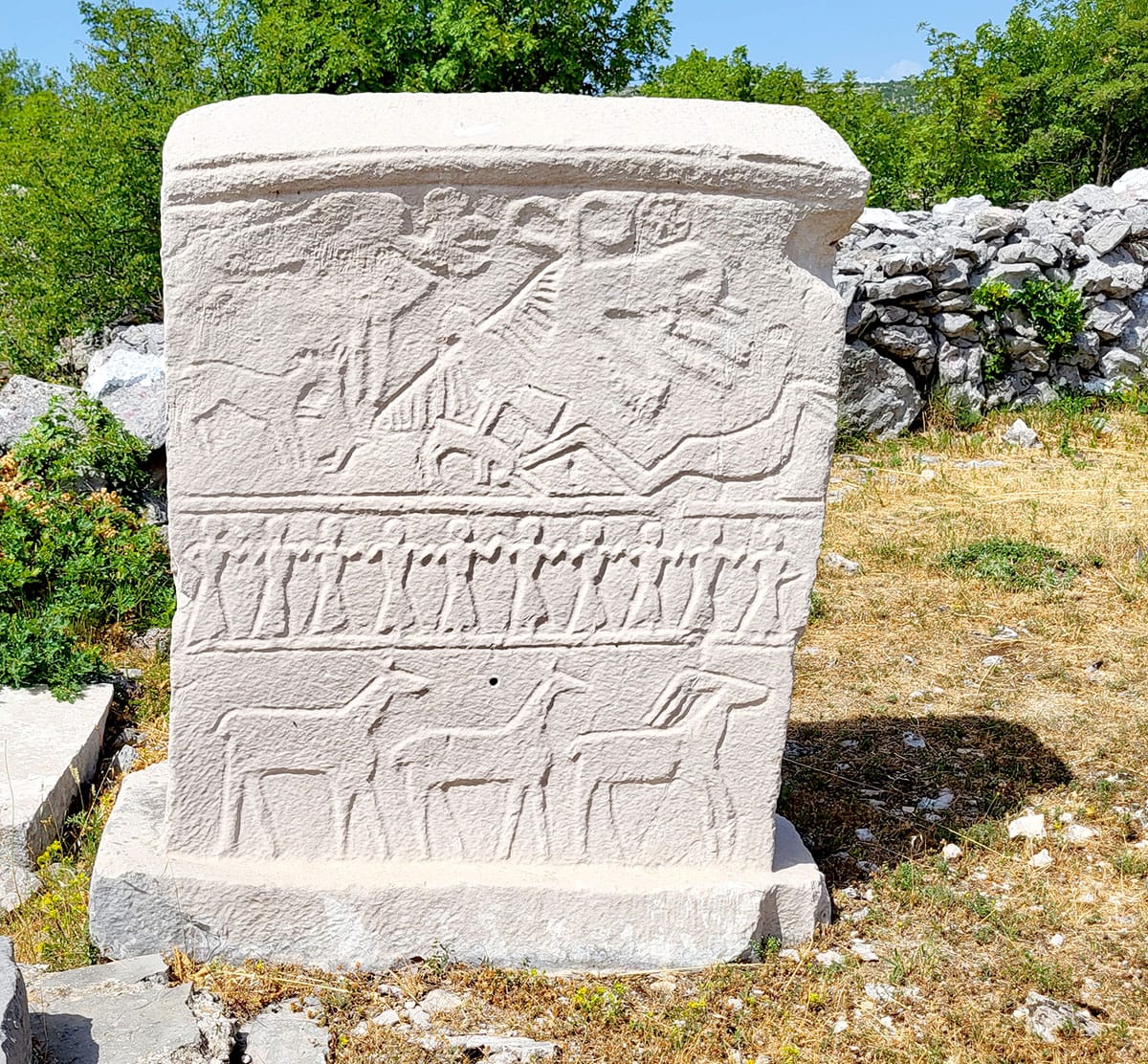 Stećak in Brotnice bei Dubrovnik mit Darstellungen von Hirschen, eines Kolo-Tanzes und des Ringens zwischen Gut und Böse
